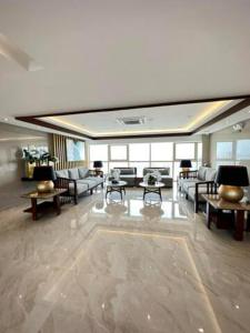 uma grande sala de estar com sofás e mesas em Coast Residences Penthouse with skyline and manila bay view em Manilla