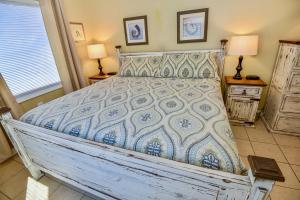 een slaapkamer met een bed met een blauwe en witte sprei bij Clearwater 6D in Gulf Shores
