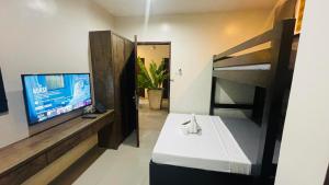 salon z telewizorem i łóżkiem piętrowym w obiekcie A&E Apartelle w mieście Bacolod