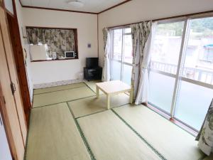 a living room with a window and a chair at Okinawa Resort in Zamami