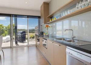 a kitchen with a sink and a view of a grill at St Andrews Beach apartment 4 01 in Fingal