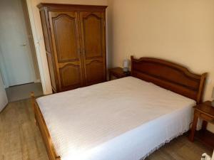 1 dormitorio con 1 cama y armario de madera en Appartement Notre-Dame-de-Monts, 2 pièces, 4 personnes - FR-1-540-238, en Notre-Dame-de-Monts