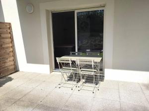 une table et des chaises assises devant une fenêtre dans l'établissement Appartement avec WIFI, terrasse, jardin, parking privé à 800m de la plage à Trébeurden - FR-1-368-386, à Trébeurden