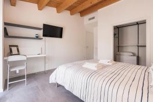 um quarto com uma cama, uma secretária e uma televisão em Come a casa - Feels like home em Polignano a Mare