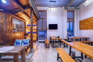 a restaurant with wooden tables and benches in a room at Tea Rhythm House Yangshuo in Yangshuo