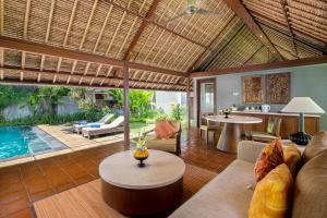 a living room with a couch and a table at Mayaloka Villas in Seminyak