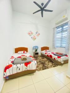 - une chambre avec 2 lits et un ventilateur de plafond dans l'établissement SARASERA HOMESTAY with PRIVATE POOL MELAKA, à Malacca