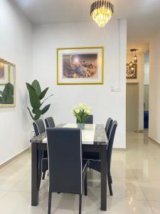 une salle à manger avec une table et des chaises noires dans l'établissement SARASERA HOMESTAY with PRIVATE POOL MELAKA, à Malacca