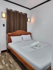 um quarto com uma cama com uma cabeceira de madeira em 3 Sisters Guest House 2 em Moalboal