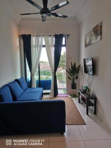 a living room with a blue couch and a window at Platino Aparment @ Paradigm Mall in Johor Bahru