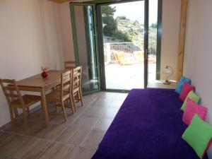 a dining room with a table and chairs and a balcony at Porto Katsiki Blu in Athani