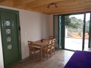 a dining room with a wooden table and chairs at Porto Katsiki Blu in Athani
