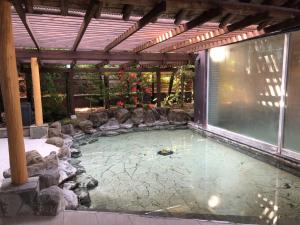 einen Pool im Hinterhof mit einer Pergola in der Unterkunft Ureshino Onsen Yusyuku Sarayama in Ureshino