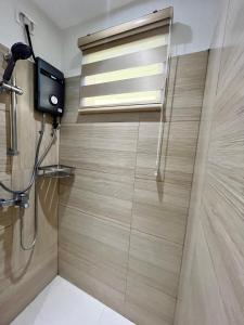 a shower with a window and a television in a bathroom at Elaiza's Cozy Home - Matina Enclaves Building C Unit 815 in Davao City