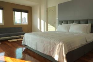 a bedroom with a large white bed and a couch at Riverfront house/Chao phraya river/Baan Rimphraya in Bangkok