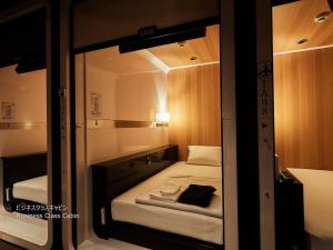 a small room with a mirror and a bed at First Cabin Nishi Umeda in Osaka +37 photos