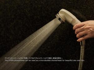 a person is holding a hair dryer at First Cabin Nishi Umeda in Osaka