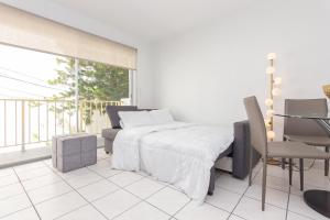 - une chambre avec un lit, une table et une fenêtre dans l'établissement Two Bedroom Apartment - with Parking & Balcony - Heart of Wynwood, à Miami