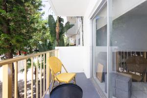 une chaise jaune assise sur le balcon d'une maison dans l'établissement Two Bedroom Apartment - with Parking & Balcony - Heart of Wynwood, à Miami