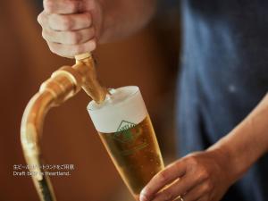 a man is drinking a glass of beer at First Cabin Nishi Umeda in Osaka