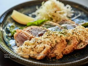 a plate of food with meat and rice at First Cabin Nishi Umeda in Osaka