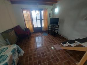 Pokój z łóżkiem i telewizorem oraz salonem w obiekcie ButaCoin2 w mieście Buta Ranquil