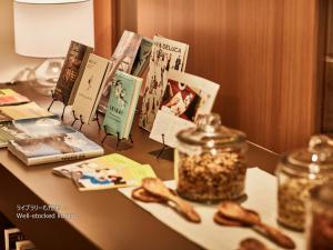 a table with books and a jar of seeds on it at First Cabin Nishi Umeda in Osaka