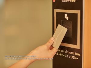 a person holding a wii remote in front of a microwave at First Cabin Nishi Umeda in Osaka