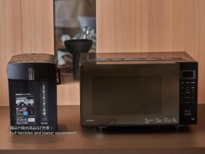 a microwave and a coffeemaker sitting on a counter at First Cabin Nishi Umeda in Osaka