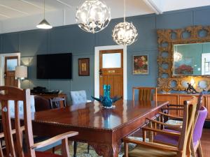 comedor con mesa de madera y sillas en Chesson Lodge, en Uki