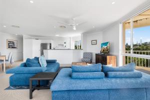 ein Wohnzimmer mit 2 blauen Sofas und einem Tisch in der Unterkunft Seamist 6 - Catch the Seamist from your penthouse in Sunrise Beach