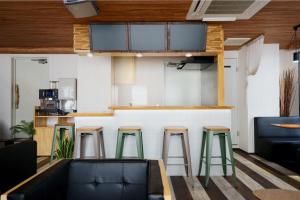 eine Bar mit grünen Stühlen in einem Zimmer in der Unterkunft Feel Osaka Yu in Osaka
