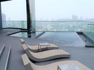 a balcony with two chairs and a pool on a building at Edge Central Pattaya Lux in Pattaya Central