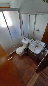 a bathroom with a toilet and a sink at Hermosa Cábaña algarrobo a pasos de la playa in Algarrobo