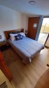 Un dormitorio con una cama con almohadas azules. en Hermosa Cábaña algarrobo a pasos de la playa, en Algarrobo