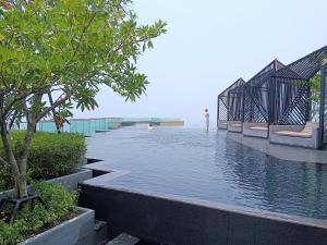a pool of water with a person standing in the water at Edge Central Pattaya Lux in Pattaya Central