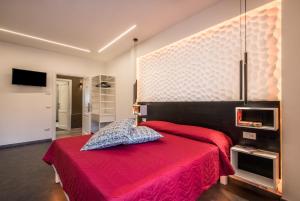 a bedroom with a red bed with a red blanket at Smart Room Abbadia S S - Camere LuxuryModernStyle con Cucina Condivisa in Abbadia San Salvatore