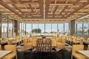 a dining room with tables and chairs and large windows at JW Marriott Jeju Resort & Spa in Seogwipo
