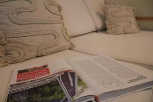 um livro sentado em cima de uma cama em Rumah Biru em Flying Fish Cove