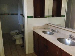 a bathroom with two sinks and a toilet at La Posada del Parque con baño privado in Salta