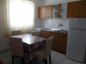cocina con mesa, sillas y nevera en Apartments Gor en Sevid