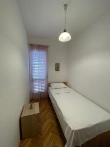 Habitación pequeña con 2 camas y ventana en Apartments Maja - free parking, en Novalja