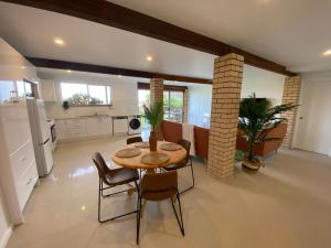 a kitchen and dining room with a table and chairs at Wave Cave Suite in Coffs Harbour