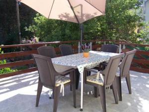 una mesa y sillas con una sombrilla en el patio en Apartments Maja - free parking, en Novalja