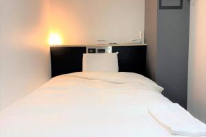 - un lit blanc avec une tête de lit noire dans la chambre dans l'établissement Ramada Encore by Wyndham Amagasaki, à Amagasaki