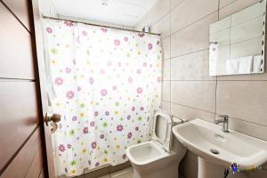 een badkamer met een toilet, een wastafel en een douchegordijn bij Verjandel Residences in Manilla