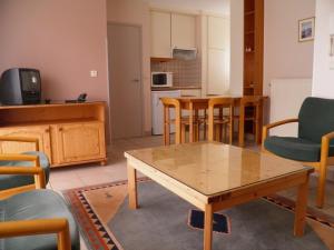 Il comprend un salon avec une table et des chaises ainsi qu'une cuisine. dans l'établissement Domein Westhoek Apartment, à Oostduinkerke