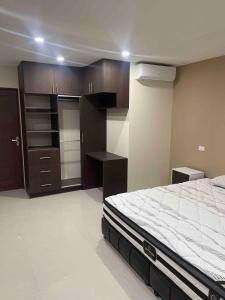 a bedroom with a bed and wooden cabinets at Hermosa Casa Minimalista cerca a la Naturaleza in Cochabamba