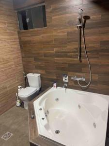 a bathroom with a bath tub and a toilet at Hermosa Casa Minimalista cerca a la Naturaleza in Cochabamba