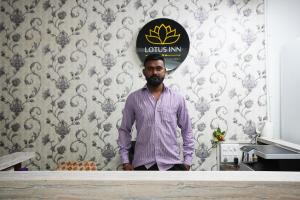 un hombre de pie junto a un mostrador en una cocina en Hotel Lotus Inn en Udaipur
